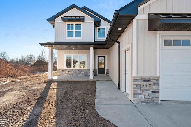 doorway to property featuring covered porch and a garage