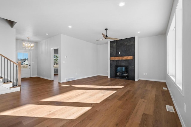 unfurnished living room featuring a tiled fireplace, a wealth of natural light, and hardwood / wood-style floors