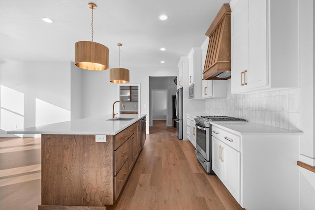 kitchen featuring white cabinetry, an island with sink, pendant lighting, and appliances with stainless steel finishes