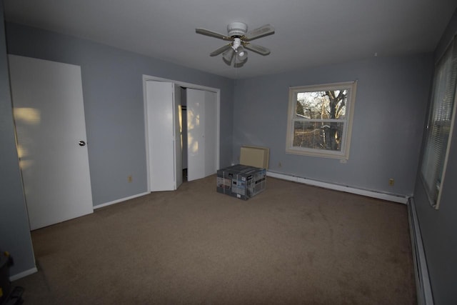 empty room featuring ceiling fan, a baseboard radiator, and dark carpet