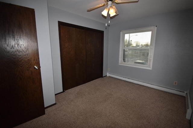 unfurnished bedroom featuring a closet, carpet floors, a baseboard radiator, and ceiling fan