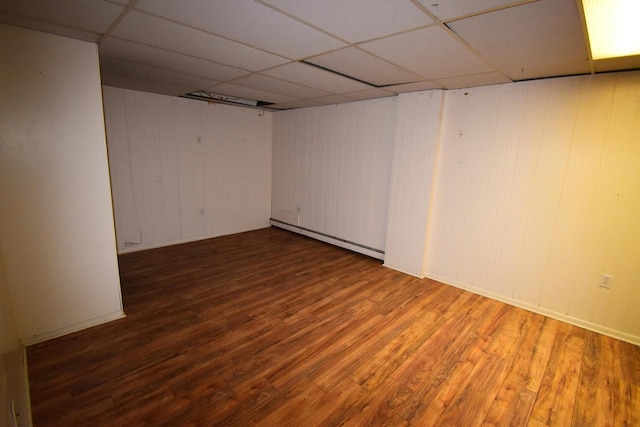 basement with hardwood / wood-style floors, a baseboard radiator, and a drop ceiling