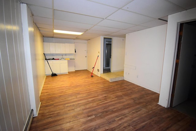 basement with a paneled ceiling and hardwood / wood-style flooring