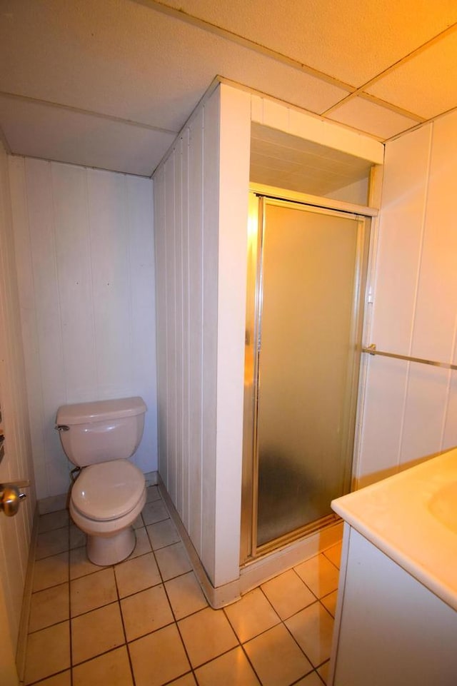 bathroom with tile patterned floors, a shower with door, vanity, and toilet