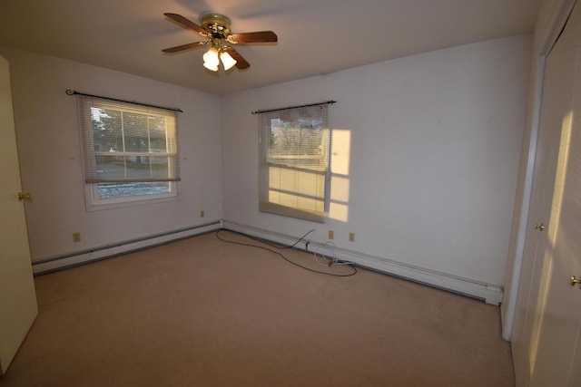 empty room featuring light carpet, baseboard heating, and ceiling fan