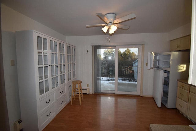 unfurnished dining area featuring wood-type flooring, ceiling fan, and a baseboard heating unit