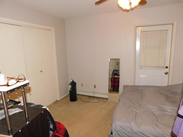 carpeted bedroom with ceiling fan, a closet, and a baseboard radiator