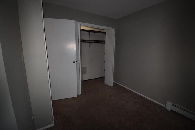 unfurnished bedroom with a closet, a baseboard radiator, and dark colored carpet