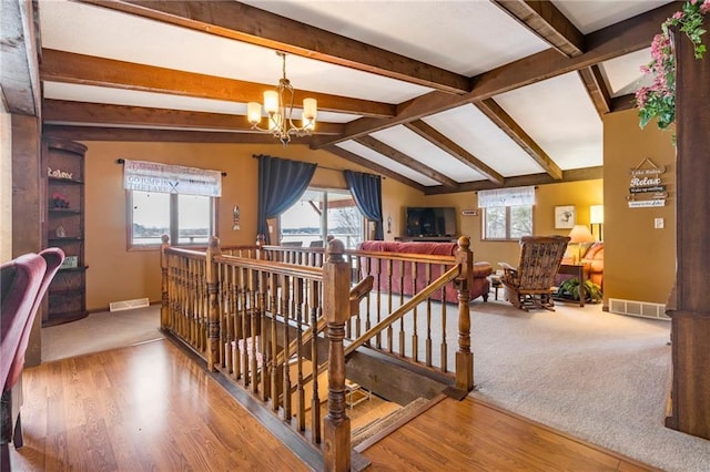 hall featuring hardwood / wood-style flooring, lofted ceiling with beams, and an inviting chandelier