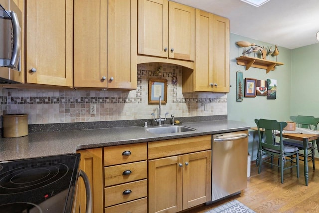 kitchen with light hardwood / wood-style floors, sink, appliances with stainless steel finishes, and tasteful backsplash