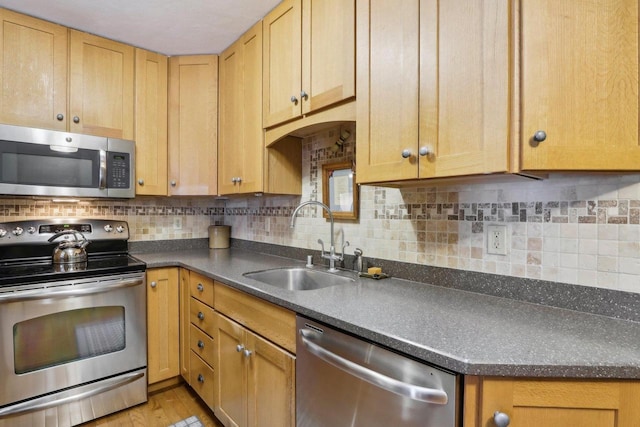 kitchen featuring backsplash, sink, stainless steel appliances, and light hardwood / wood-style flooring