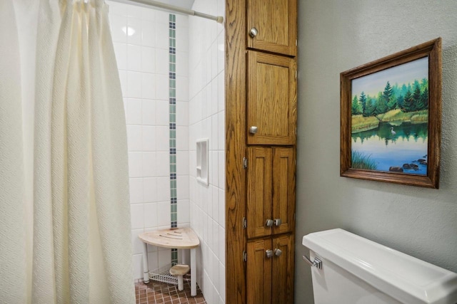 bathroom featuring tile patterned floors, walk in shower, tile walls, and toilet