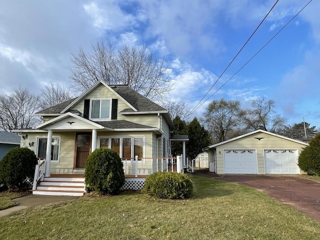 bungalow with an outbuilding, covered porch, a front yard, and a garage