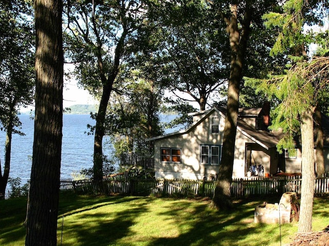 view of side of home with a lawn and a water view