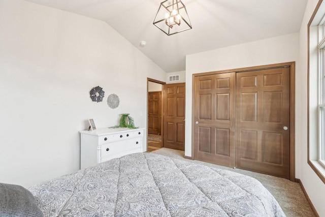 bedroom with lofted ceiling, a closet, visible vents, carpet flooring, and a chandelier