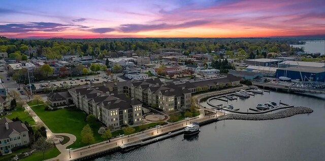 aerial view at dusk featuring a water view