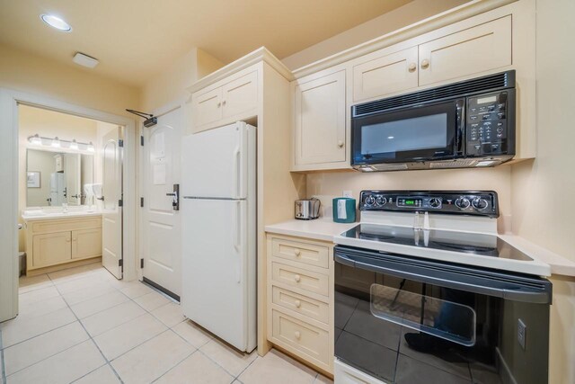 kitchen with sink, light tile patterned flooring, and black appliances