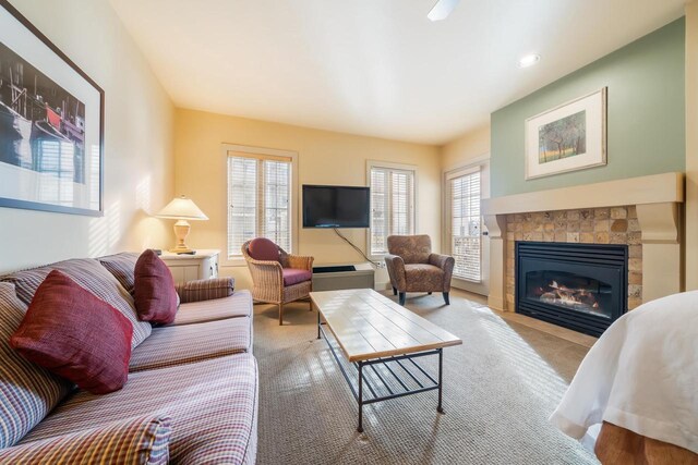 carpeted living room featuring a tile fireplace