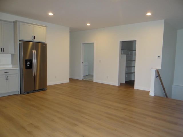 kitchen with stainless steel refrigerator with ice dispenser and light wood-type flooring