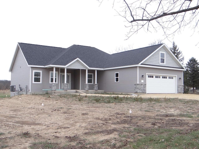 view of front of home with a porch, a garage, and central air condition unit