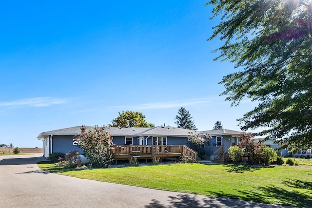 single story home with a front yard and a wooden deck