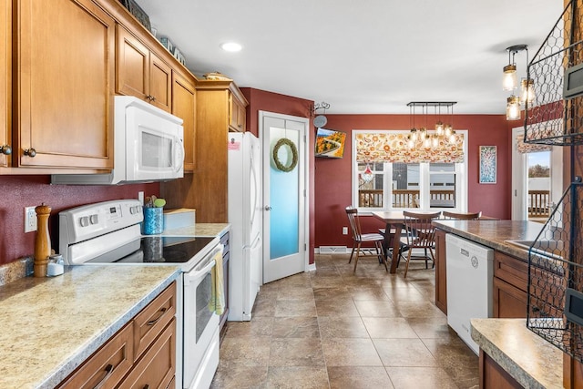 kitchen with white appliances, an inviting chandelier, and hanging light fixtures