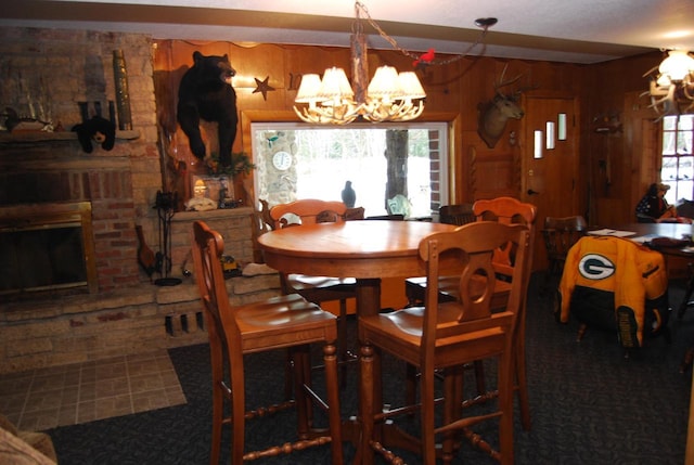 dining space with a chandelier, plenty of natural light, and wooden walls