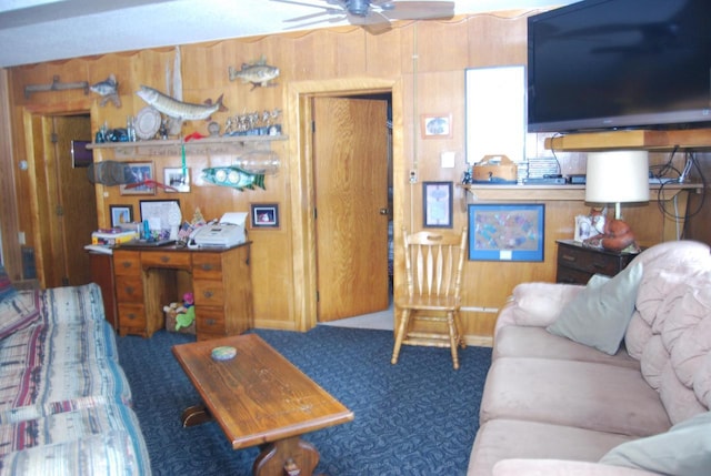 carpeted living room with ceiling fan and wood walls