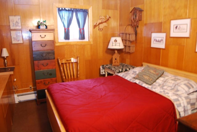 bedroom with a baseboard heating unit and wood walls