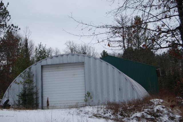 snow covered structure featuring a garage