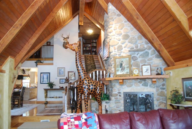 living room featuring a stone fireplace, beamed ceiling, and wooden ceiling