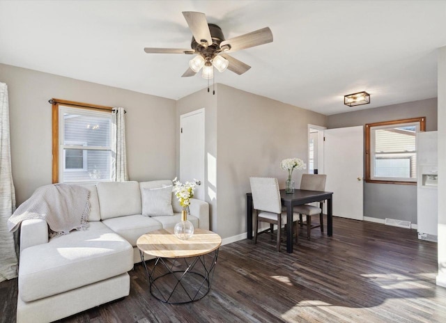 living room featuring ceiling fan and dark wood-type flooring