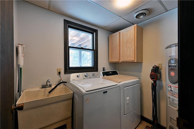 washroom featuring electric water heater, cabinets, separate washer and dryer, and sink