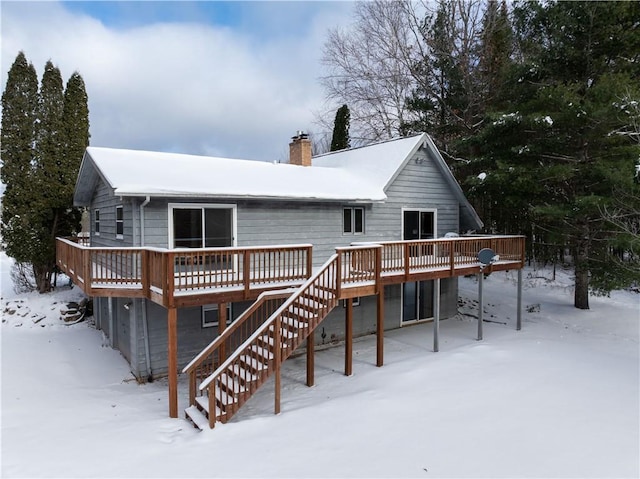 snow covered house featuring a deck