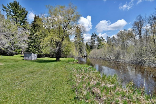 view of yard with a water view and a storage shed