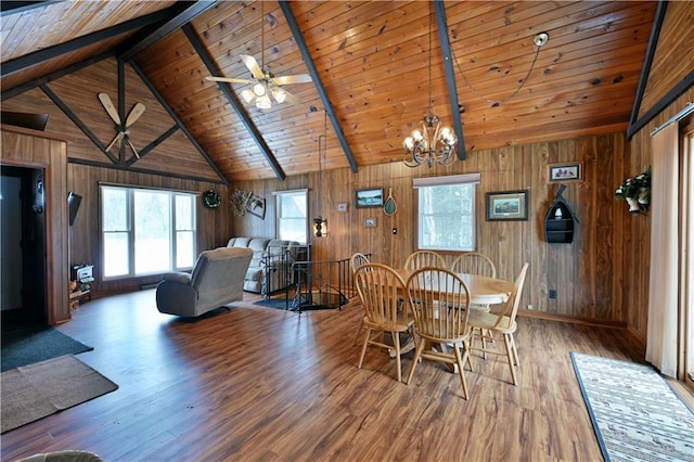 dining area with ceiling fan with notable chandelier, wooden walls, beam ceiling, hardwood / wood-style flooring, and wooden ceiling