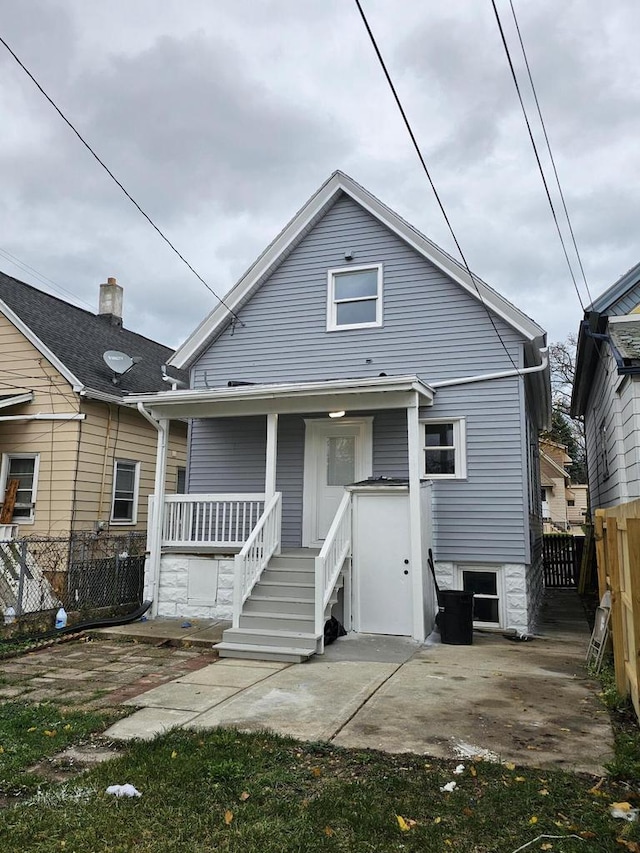 back of property featuring covered porch