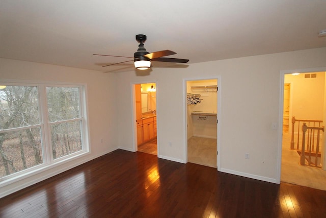 interior space with dark hardwood / wood-style flooring, a walk in closet, connected bathroom, and a closet