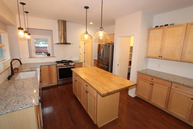 kitchen with appliances with stainless steel finishes, dark hardwood / wood-style flooring, sink, wall chimney range hood, and a kitchen island