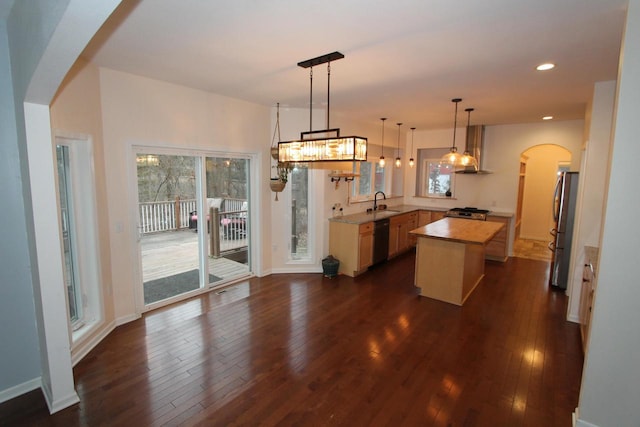 kitchen featuring a center island, wood counters, dark hardwood / wood-style flooring, decorative light fixtures, and appliances with stainless steel finishes