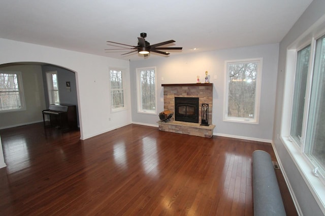 unfurnished living room featuring ceiling fan, dark hardwood / wood-style flooring, and a fireplace