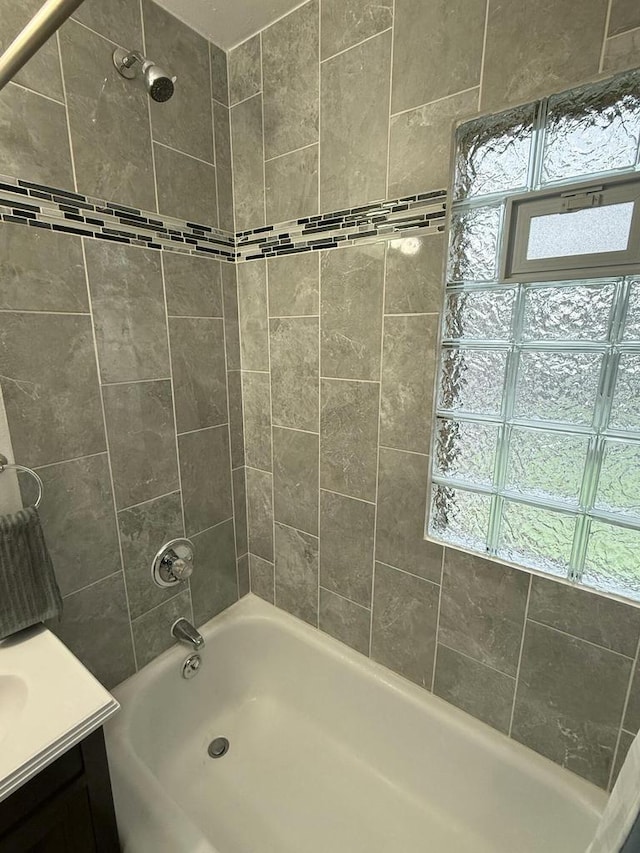 bathroom featuring vanity and tiled shower / bath