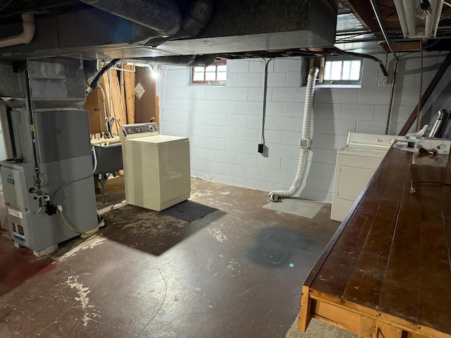 basement with washing machine and dryer, heating unit, and sink