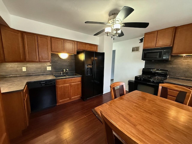 kitchen featuring dark hardwood / wood-style flooring, sink, backsplash, and black appliances