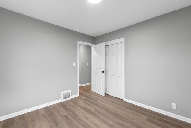 unfurnished bedroom with a closet and light wood-type flooring