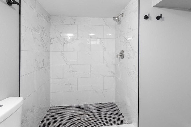 bathroom with tiled shower and toilet