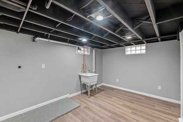 basement with sink and hardwood / wood-style flooring