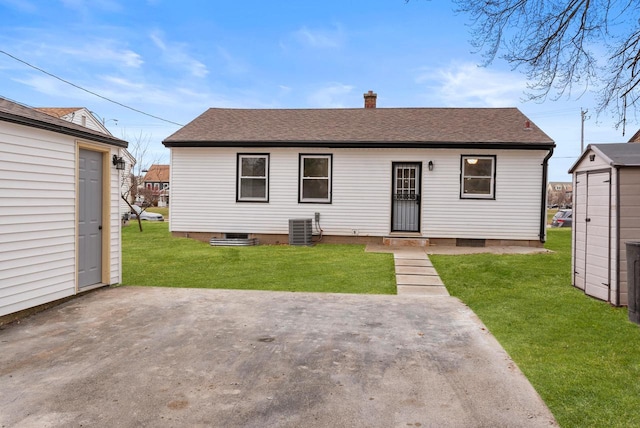 back of property with central air condition unit, a patio area, and a lawn