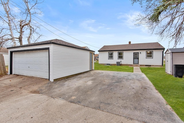 view of front of house with central AC unit, a garage, a shed, and a front lawn