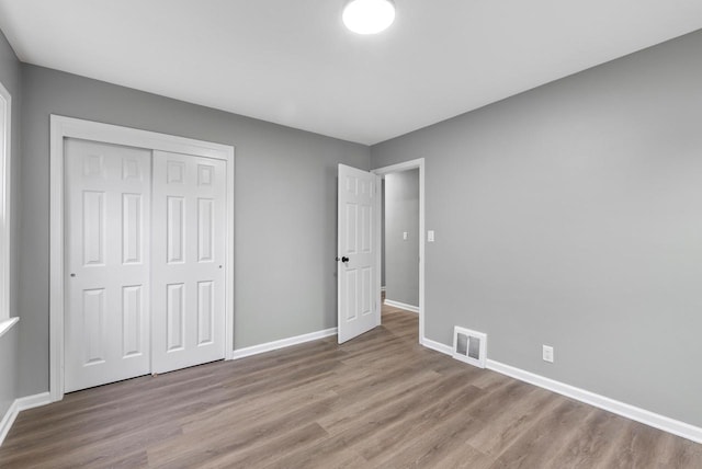 unfurnished bedroom with a closet and light hardwood / wood-style floors